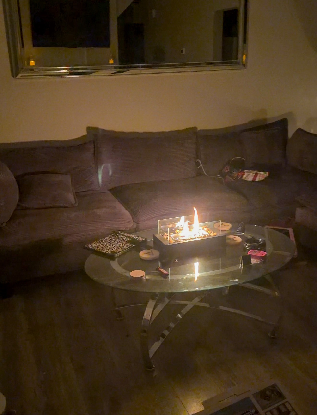 A dark living room lit by a small tabletop fireplace during a power outage