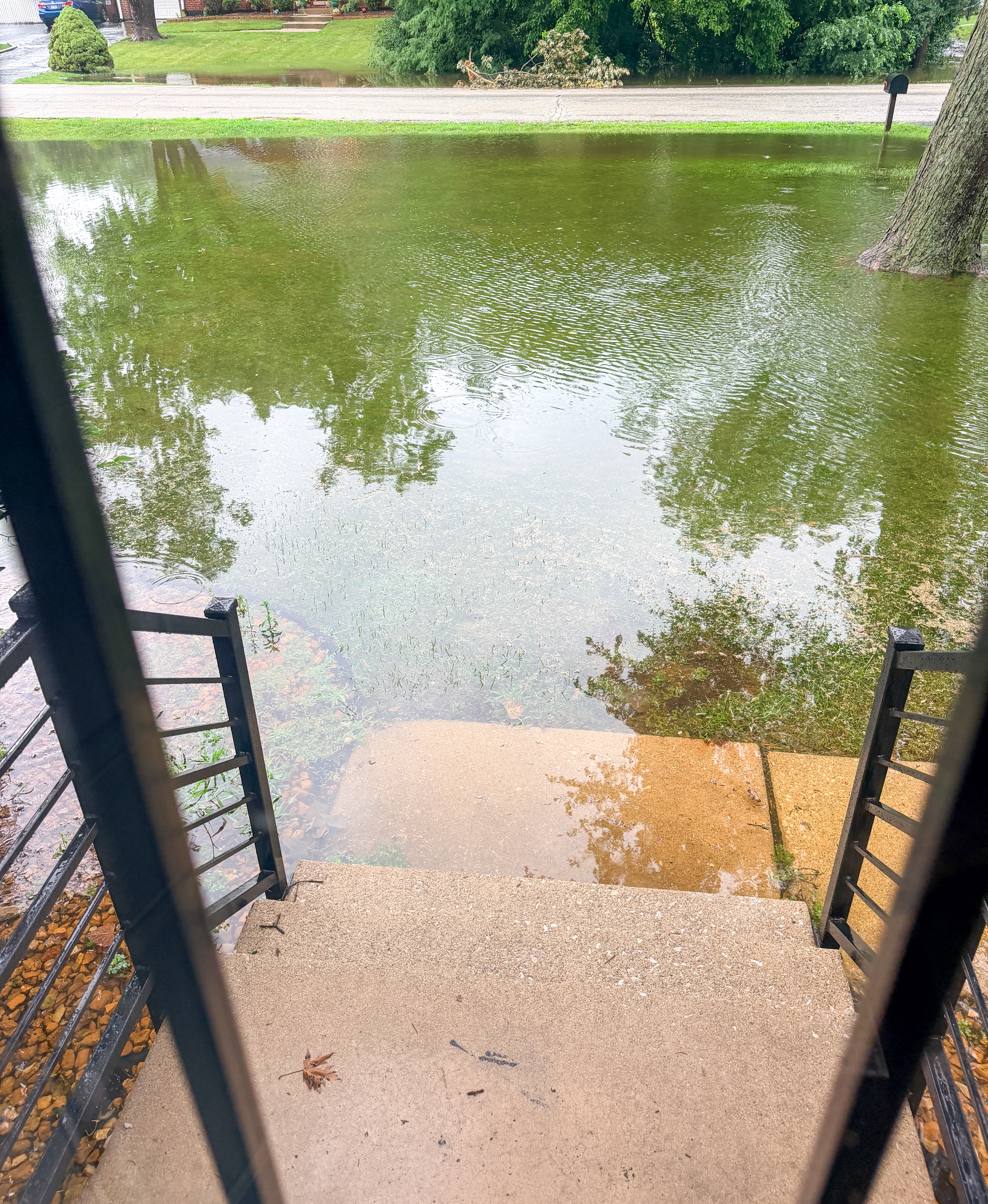 Flood water covering a front yard after a severe storm